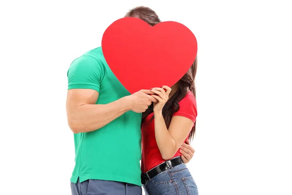Couple kissing behind red heart — Stock Photo, Image