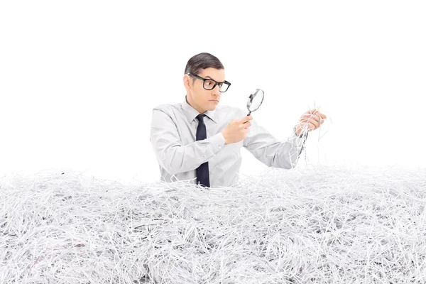 Homme examinant un tas de papier déchiqueté — Photo