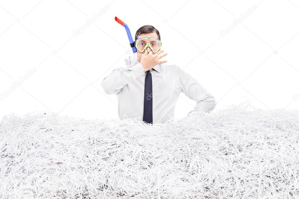 Businessman diving into shredded paper