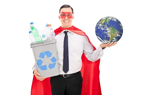 Супергерой держит мусорную корзину и землю — стоковое фото