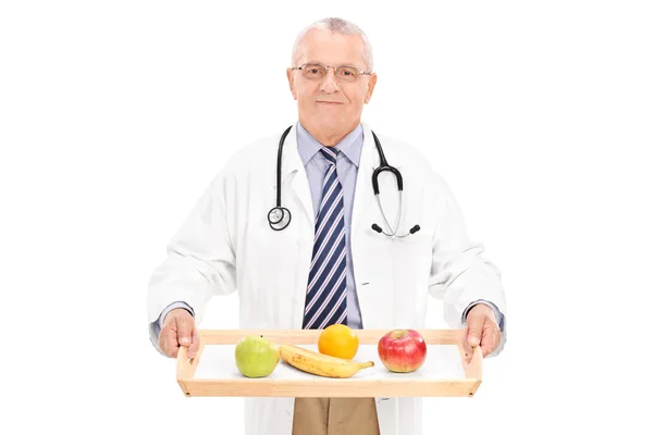 Médico maduro segurando bandeja com frutas — Fotografia de Stock