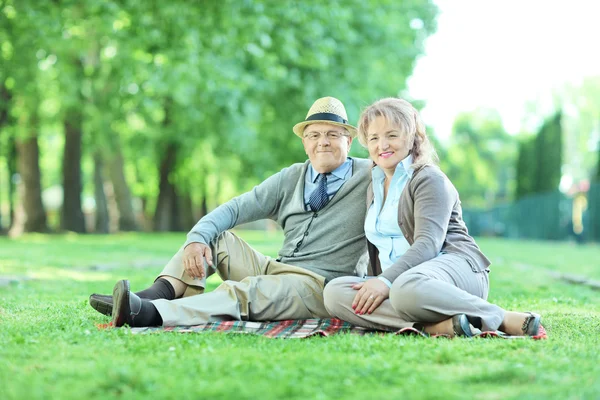Couple d'âge mûr sur couverture dans le parc — Photo