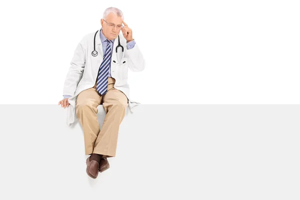 Mature doctor on blank panel — Stock Photo, Image