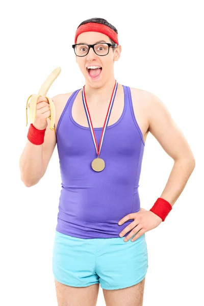 Юный спортсмен ест банан — стоковое фото