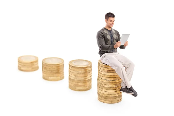 Man seated on pile of coins — Stock Photo, Image