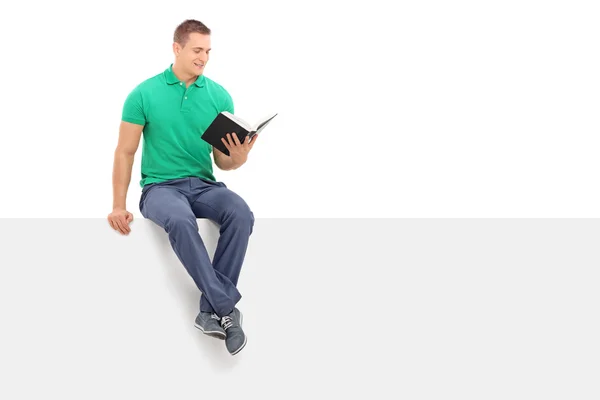 Man reading book on signboard — Stock Photo, Image