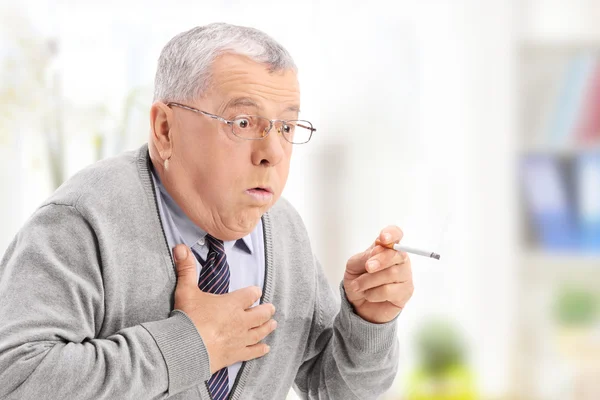 Senior man choking from smoke — Stock Photo, Image