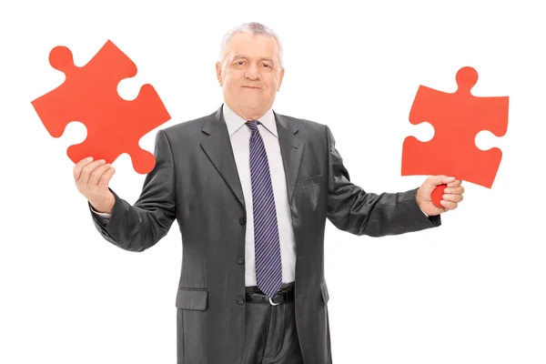 Mature businessman holding puzzle — Stock Photo, Image