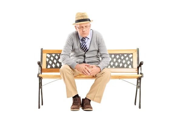 Sad senior seated on bench — Stock Photo, Image