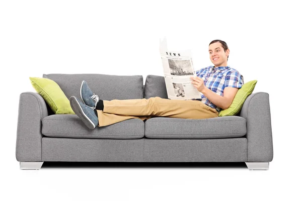 Man lezing nieuws op sofa — Stockfoto