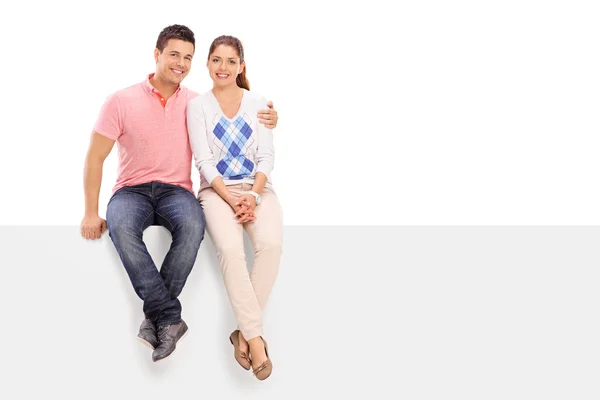 Couple seated on blank panel — Stock Photo, Image