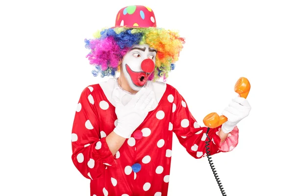 Surprised clown holding telephone speaker — Stock Photo, Image