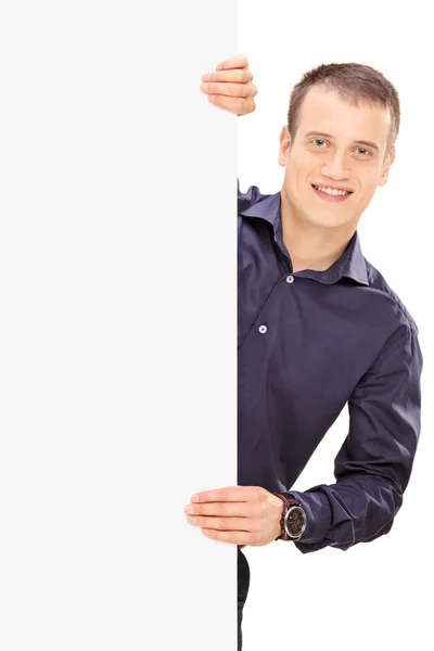 Cheerful young guy behind panel — Stock Photo, Image