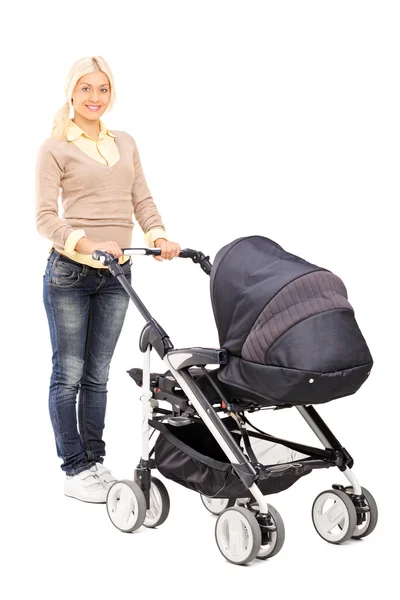 Young mother pushing baby stroller — Stock Photo, Image