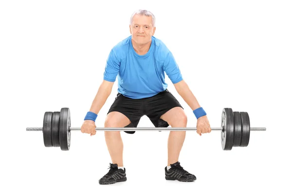 Mature man lifting heavy weight — Stock Photo, Image