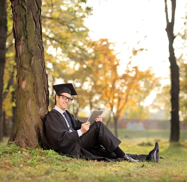 Graduado estudante segurando tablet — Fotografia de Stock