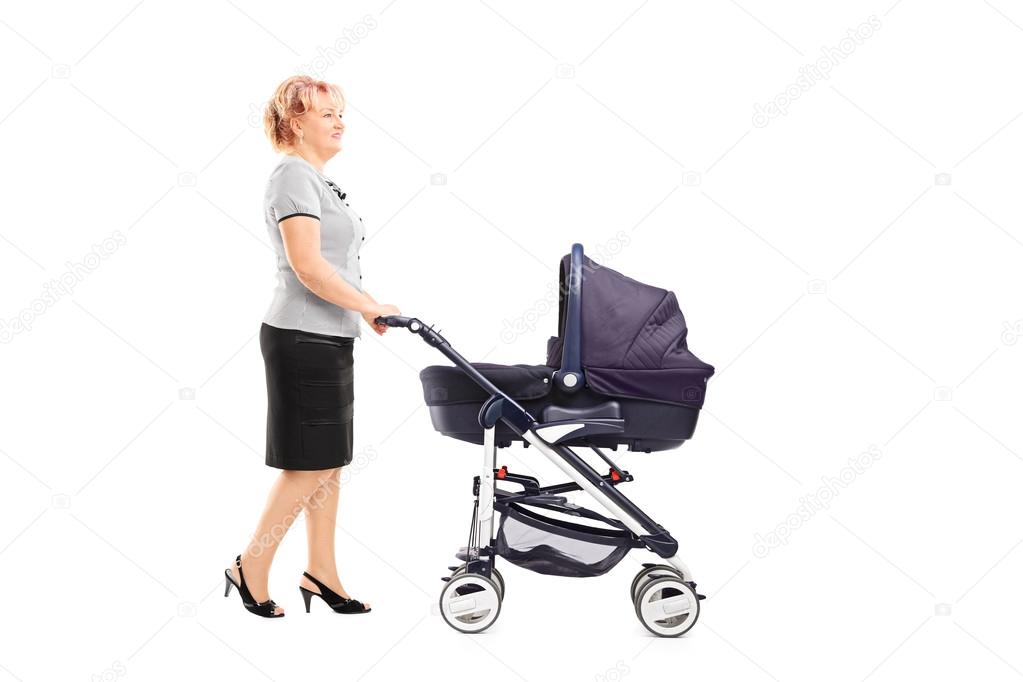 Mature woman pushing baby stroller