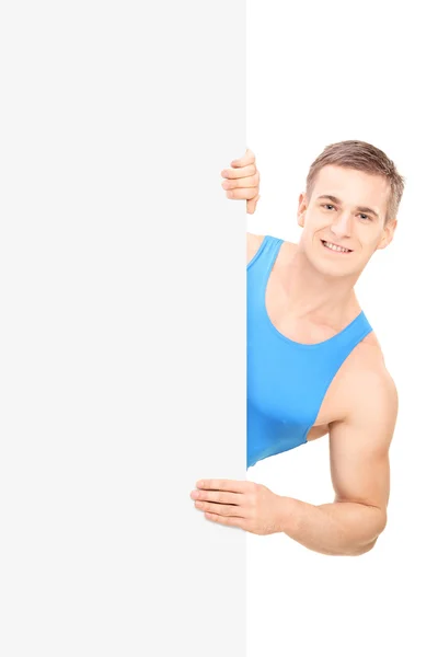Male athlete standing behind signboard — Stock Photo, Image