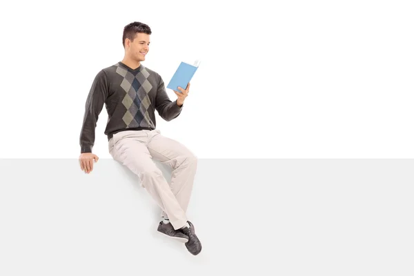 Guy reading book on panel — Stock Photo, Image