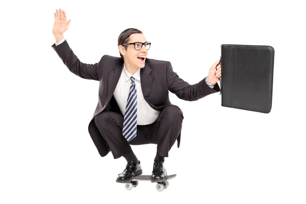 Excited businessman riding a skateboard — Stock Photo, Image