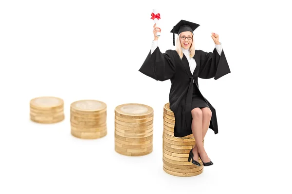 Feminino graduado sentado em moedas — Fotografia de Stock