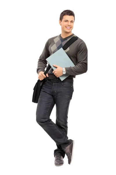Jovem estudante do sexo masculino segurando notebook — Fotografia de Stock