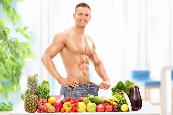 Человек за столом с овощами — стоковое фото