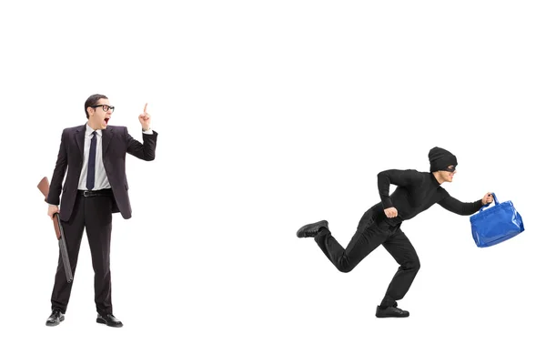 Businessman with rifle chasing thief — Stock Photo, Image