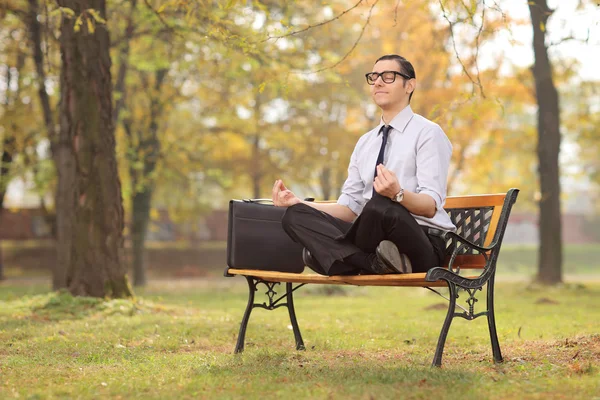 Businessman meditating in park — Stock Photo, Image