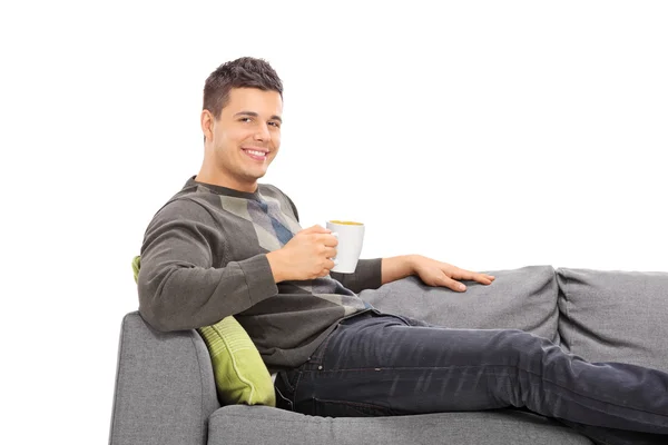 Mann trinkt Kaffee auf Sofa — Stockfoto