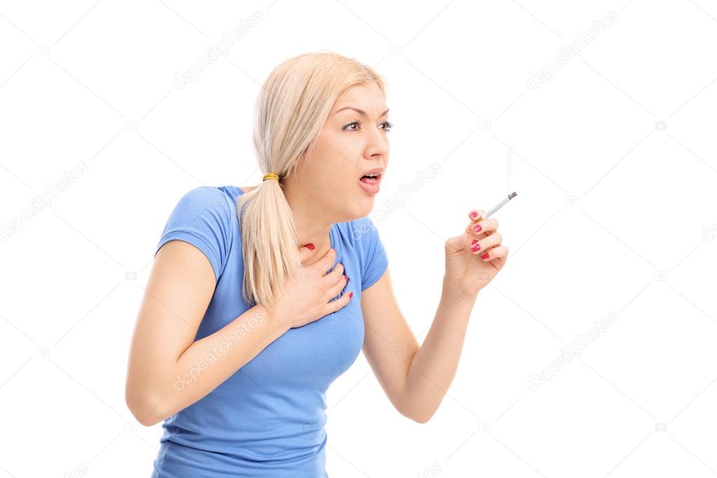Young woman coughing from cigarette