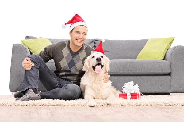 Adam ve köpeği ile Noel Baba şapkaları — Stok fotoğraf