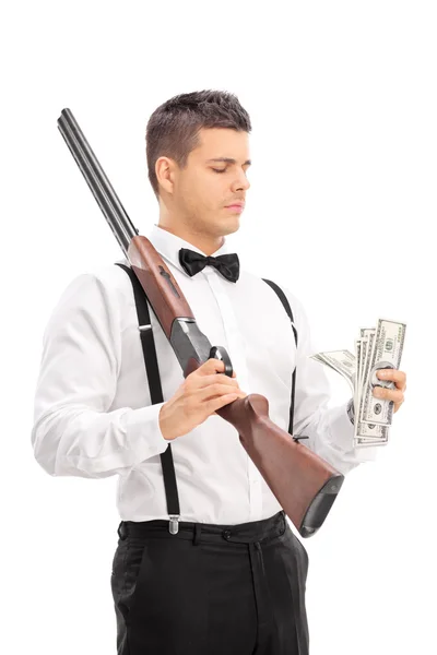 Man with shotgun counting money — Stock Photo, Image