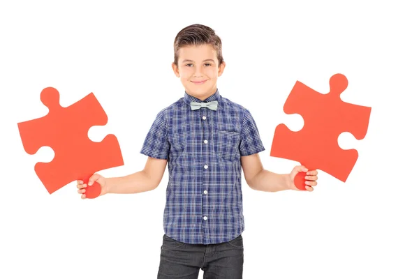 Niño sosteniendo piezas del rompecabezas — Foto de Stock