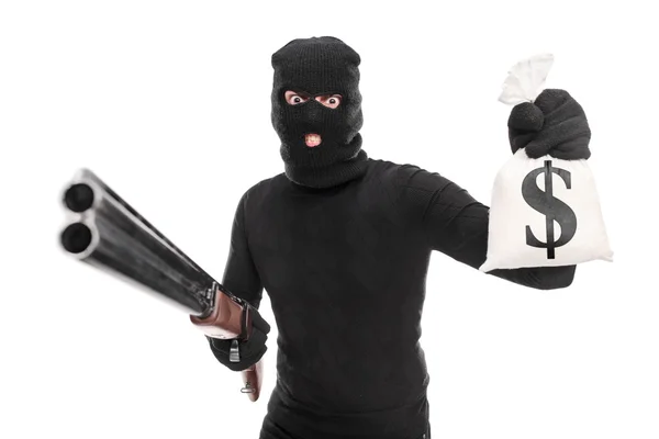 Inbreker bedrijf geld en shotgun — Stockfoto