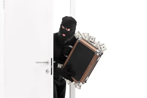 Thief with money entering a room — Stock Photo, Image