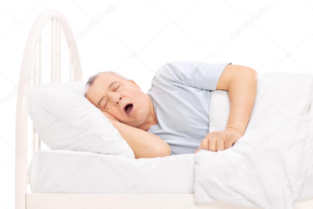 Mature man sleeping in bed