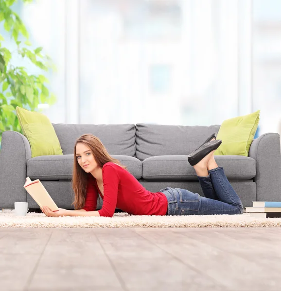 Frau liest Buch auf dem Fußboden — Stockfoto