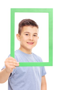 Resim çerçevesi arkasında küçük çocuk