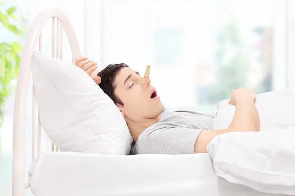 Man sleeping with clothespin on nose — Stock Photo, Image