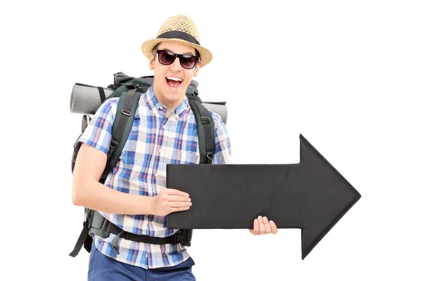 Emocionado turista masculino sosteniendo una flecha negra apuntando a la derecha — Foto de Stock