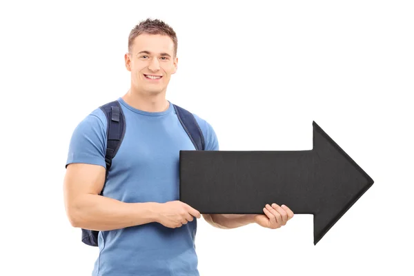 Estudante masculino segurando seta grande — Fotografia de Stock