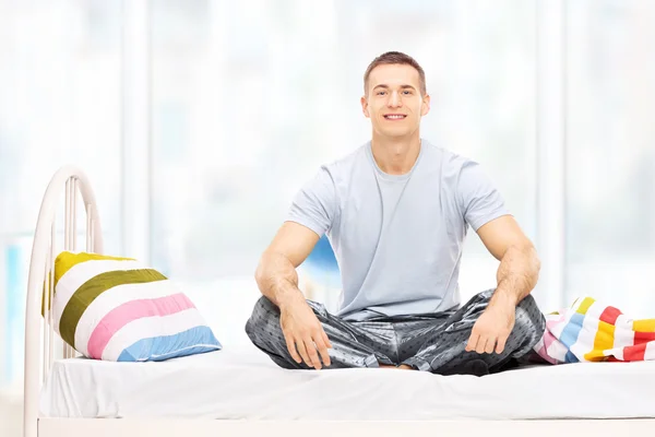 Man in pyjama's op bed — Stockfoto