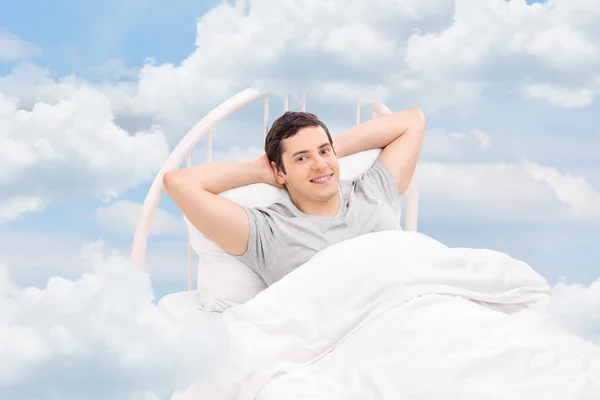 Mann entspannt sich auf bequemem Bett — Stockfoto