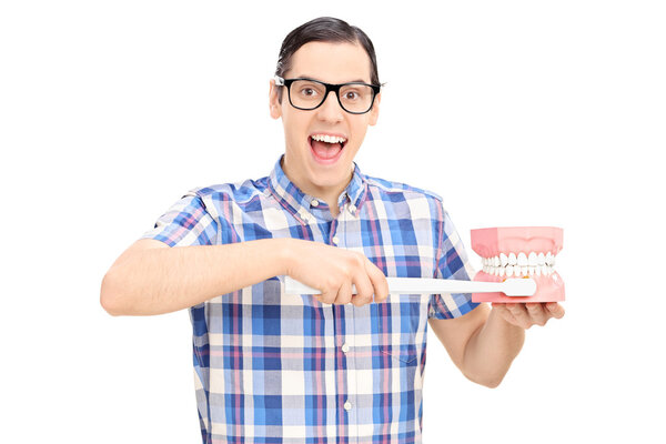 Guy holding denture and toothbrush