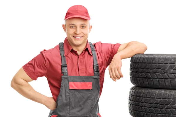 Mecánico masculino apoyado en neumáticos — Foto de Stock