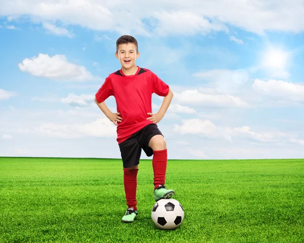 Joven de pie sobre un balón de fútbol — Foto de Stock