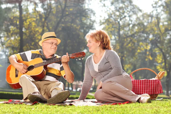 Senior man playing guitar to wife — Stock Photo, Image