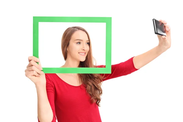 Menina tomando selfie atrás quadro — Fotografia de Stock