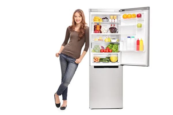 Chica apoyada en refrigerador abierto — Foto de Stock